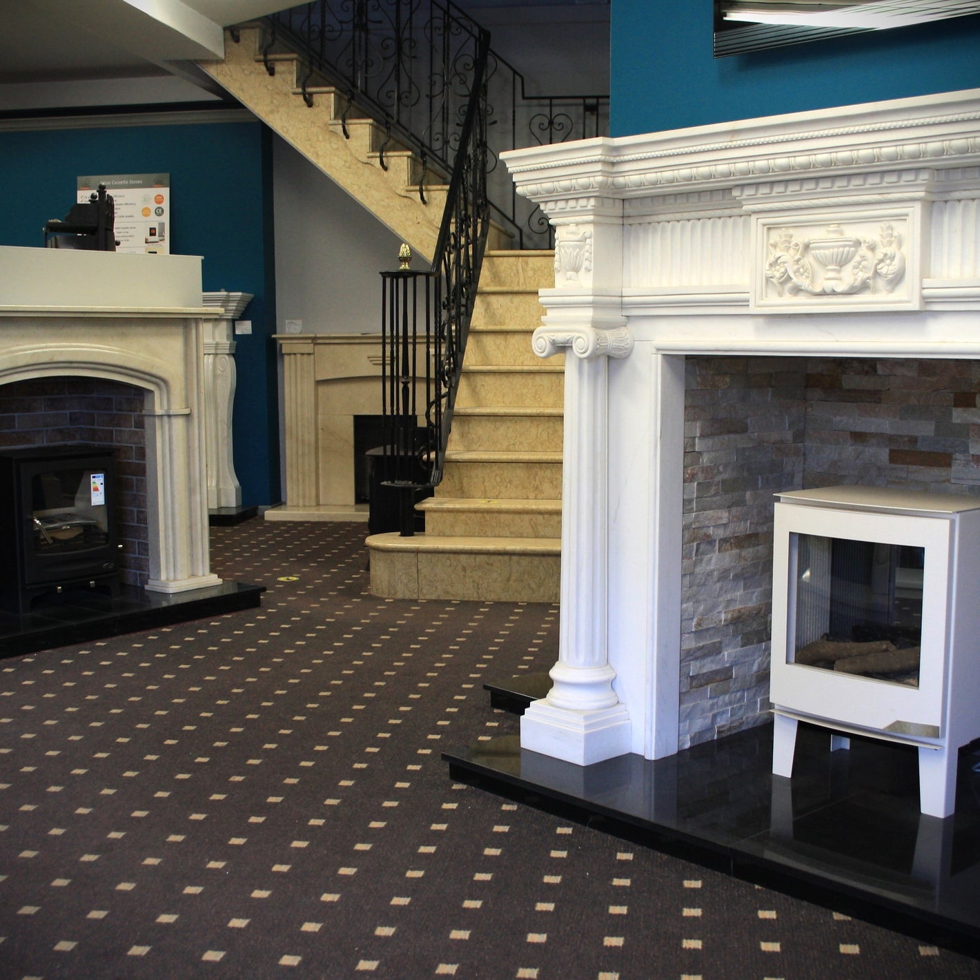 Entrance of Dunnes Fireplaces Showroom Dundalk including examples of fireplaces and stoves on display and custom marble staircase